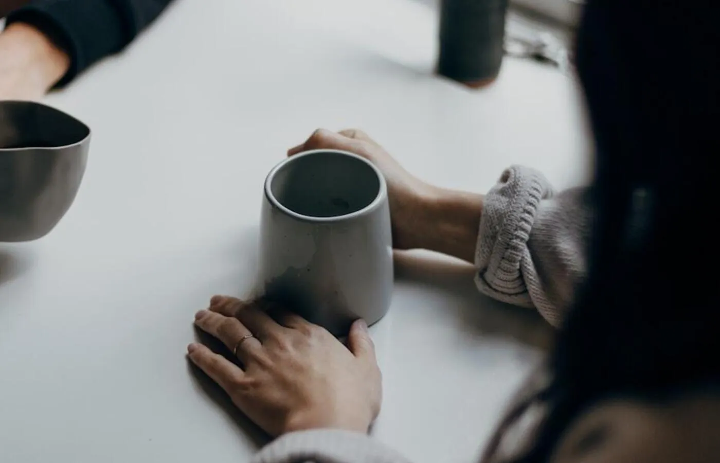 Dos personas conversando con tazas de café sobre una mesa
