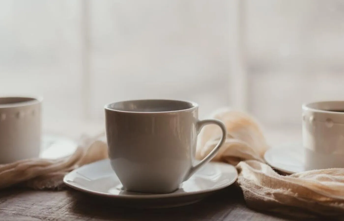 Tazas de café sobre una mesa de madera con luz cálida
